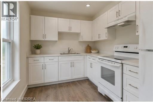 A kitchen with white cabinets and appliances.
