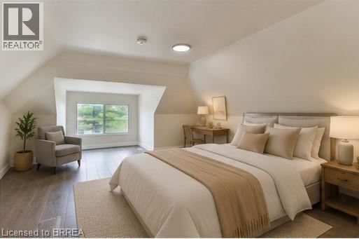 A bedroom with a large bed and a chair by a window.