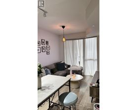 A living room with a grey couch, a white table, and a grey chair.
