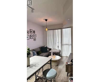 A living room with a grey couch, a white table, and a grey chair.