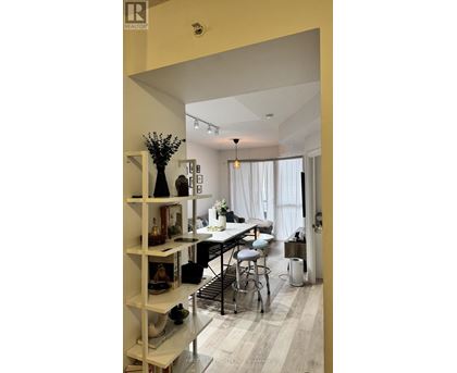 A well-lit, modern kitchen with a dining area and a bar stool.