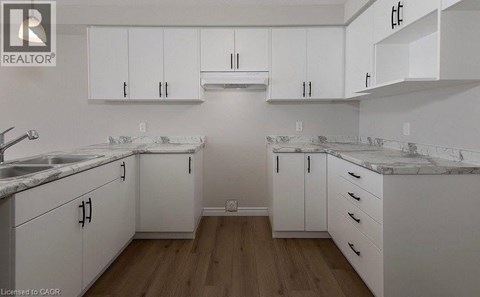 A kitchen with white cabinets and marble countertops.