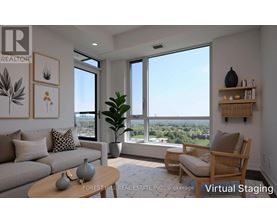 A living room with a couch, a chair, a table, and a view of the outdoors through the windows.