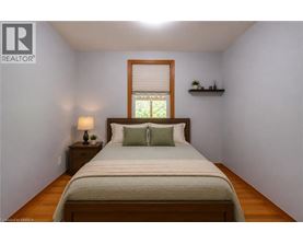 A bedroom with a bed, nightstand, and window.