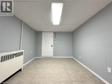 A room with a white door and a radiator on the left side.