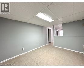 A spacious room with tile flooring and a doorway leading to another room.