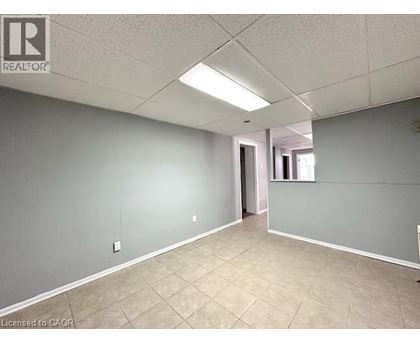 A spacious room with tile flooring and a doorway leading to another room.