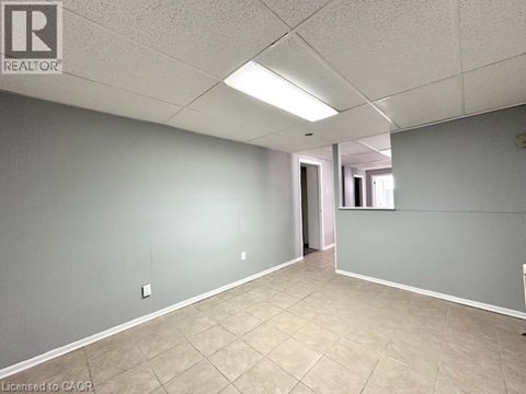 A spacious room with tile flooring and a doorway leading to another room.