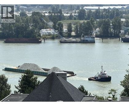 A barge carrying a load of gravel is docked in a river.