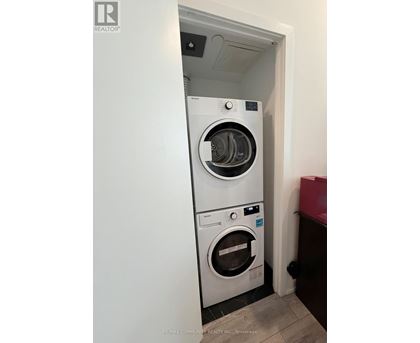A white washing machine and dryer in a small room.