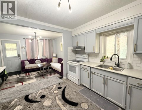 A kitchen and living room are shown in a real estate listing.