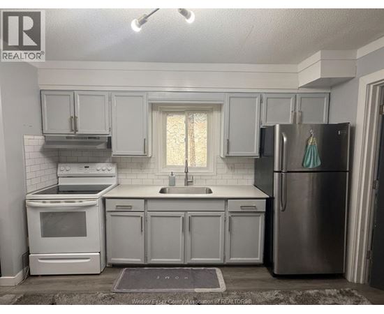A kitchen with white appliances and cabinets.