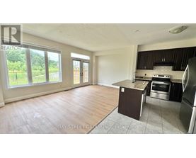 A kitchen area with a refrigerator, oven, and sink.