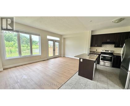 A kitchen area with a refrigerator, oven, and sink.