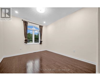 A room with a window and a view of trees outside.