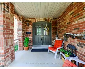 A front porch with a grey door and a red chair.