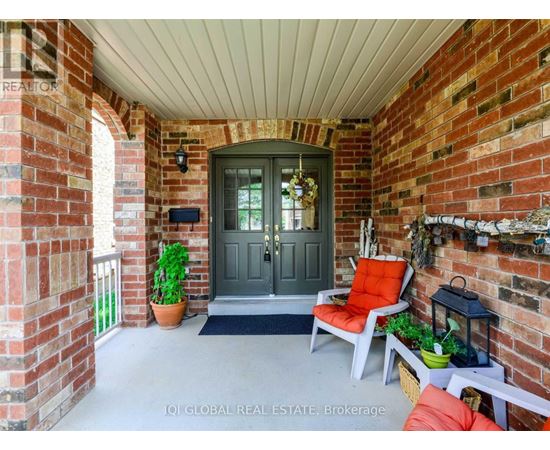 A front porch with a grey door and a red chair.