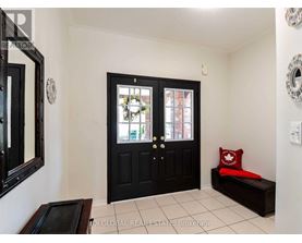 A black door with a glass window is in the middle of a white wall.