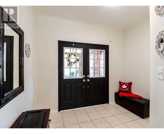 A black door with a glass window is in the middle of a white wall.