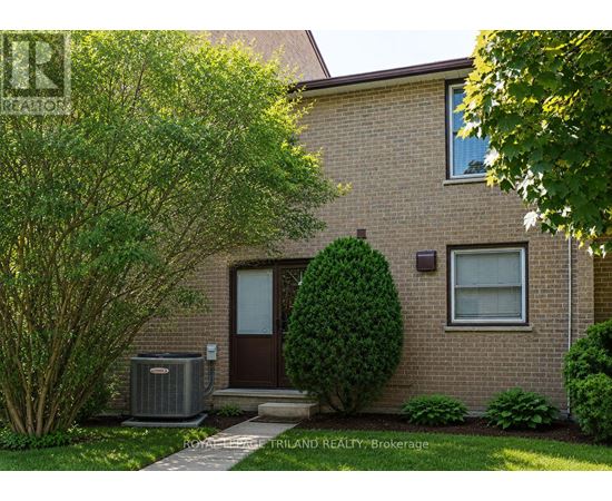 A house with a brown door and a green bush in front.