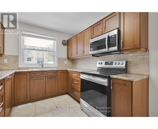 A kitchen with wooden cabinets and a black stove top oven.