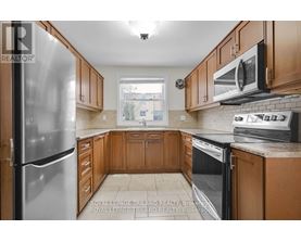 A kitchen with wooden cabinets and a stainless steel refrigerator.