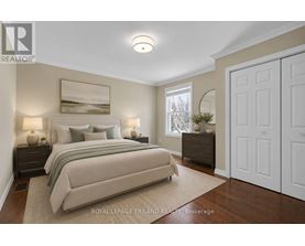 A bedroom with a large bed and a painting on the wall.
