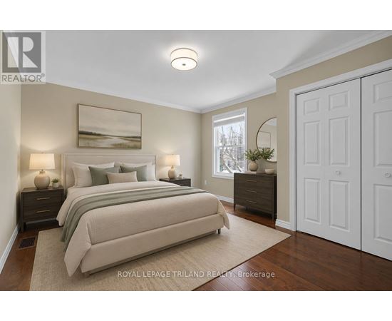 A bedroom with a large bed and a painting on the wall.