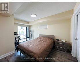 A bedroom with a bed, nightstand, and a bicycle in the corner.