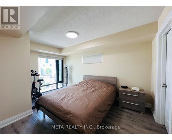 A bedroom with a bed, nightstand, and a bicycle in the corner.