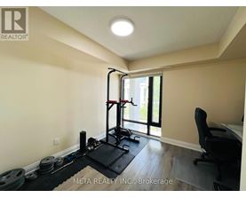 A room with a gym setup including a squat rack, weights, and a bench.