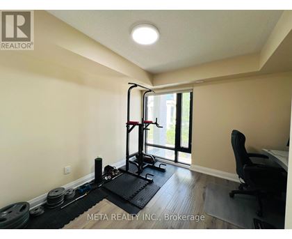 A room with a gym setup including a squat rack, weights, and a bench.