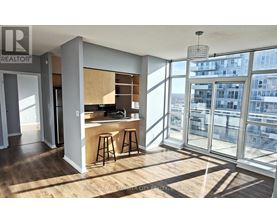 A modern kitchen with wooden floors and a bar area.
