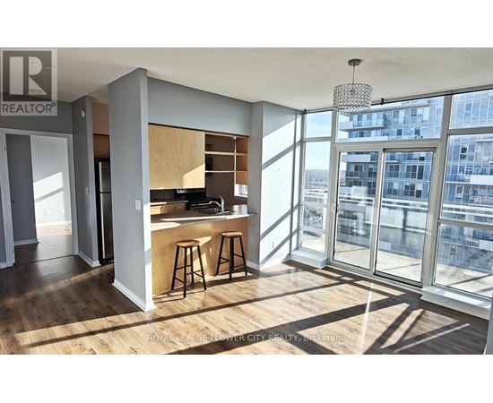 A modern kitchen with wooden floors and a bar area.