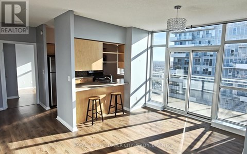 A modern kitchen with wooden floors and a bar area.