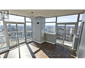 A large, empty room with floor-to-ceiling windows overlooking a cityscape.