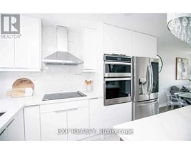 A modern kitchen with white cabinets and stainless steel appliances.