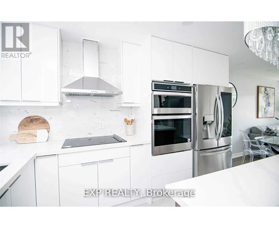 A modern kitchen with white cabinets and stainless steel appliances.