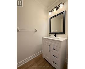 A white bathroom vanity with a black framed mirror and lights above it.