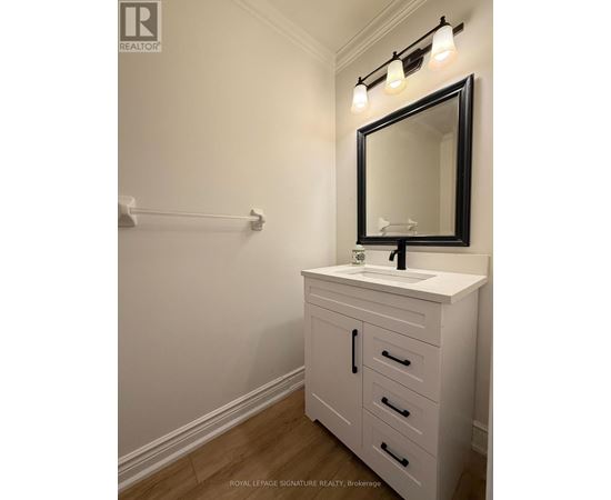 A white bathroom vanity with a black framed mirror and lights above it.