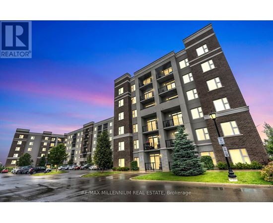 A large apartment complex with a parking lot in front.