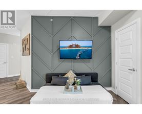 A modern bedroom with a large bed and a painting on the wall.