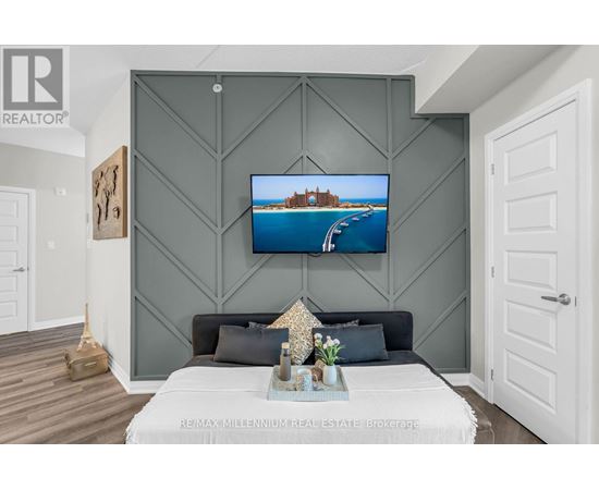 A modern bedroom with a large bed and a painting on the wall.