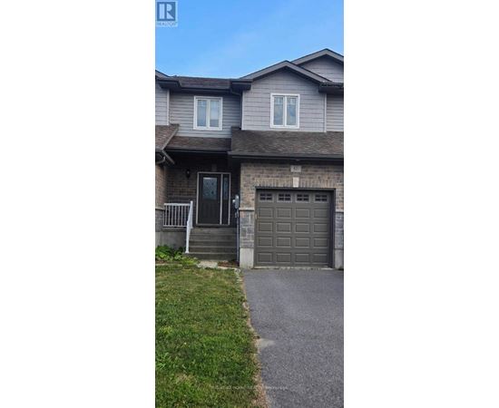 A house with a grey garage door and a brown roof.