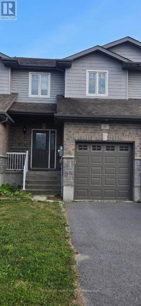 A house with a grey garage door and a brown roof.