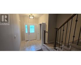 A hallway with a staircase and a door with a glass window.
