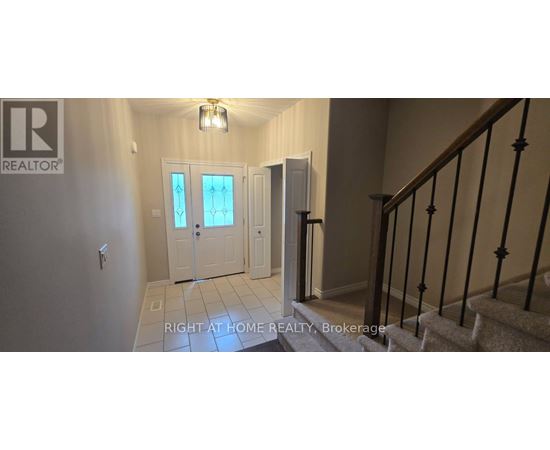 A hallway with a staircase and a door with a glass window.