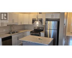 A kitchen with a refrigerator, stove, and sink.