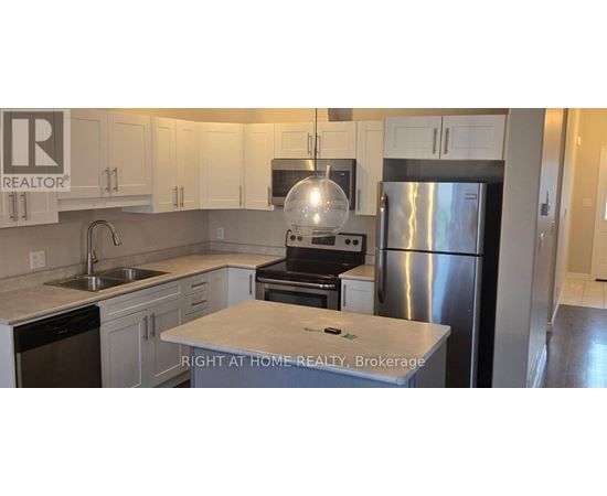 A kitchen with a refrigerator, stove, and sink.