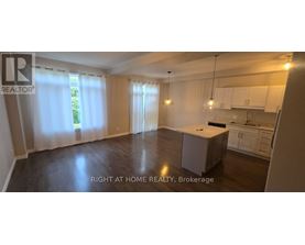A spacious room with a kitchenette and a dining area.